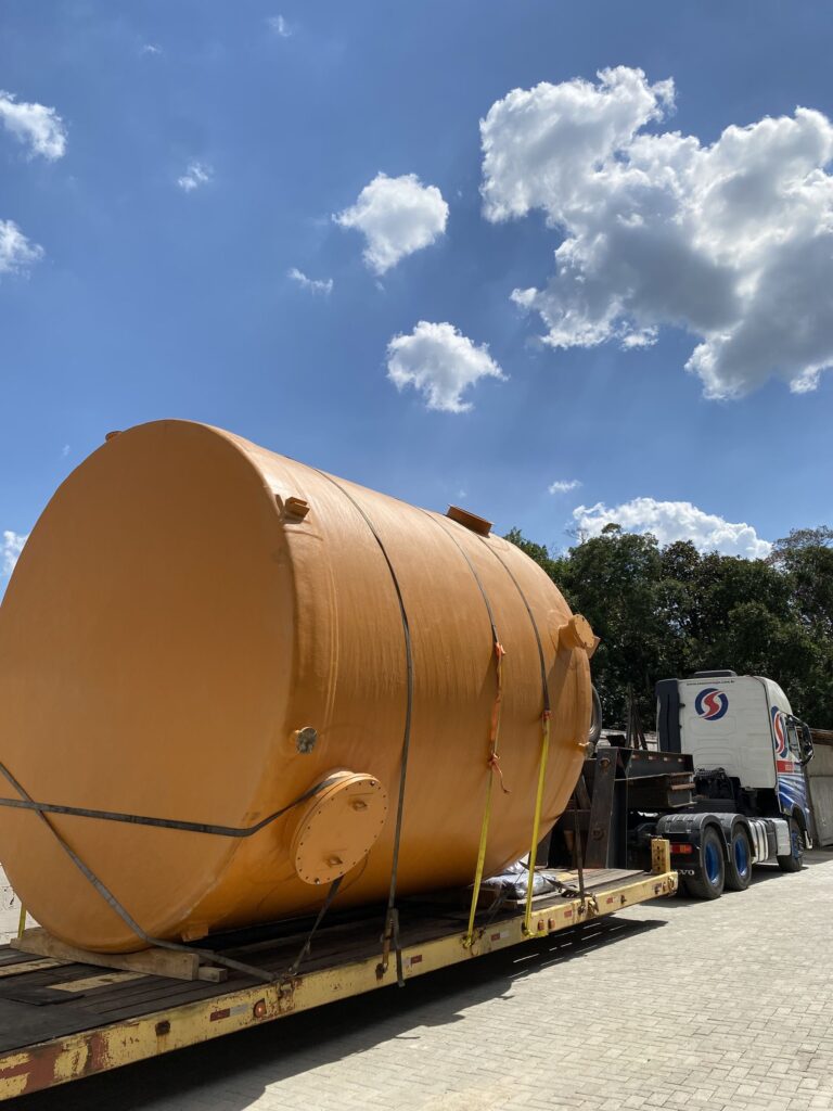 Tanque em PRFV laranja transportado em carreta